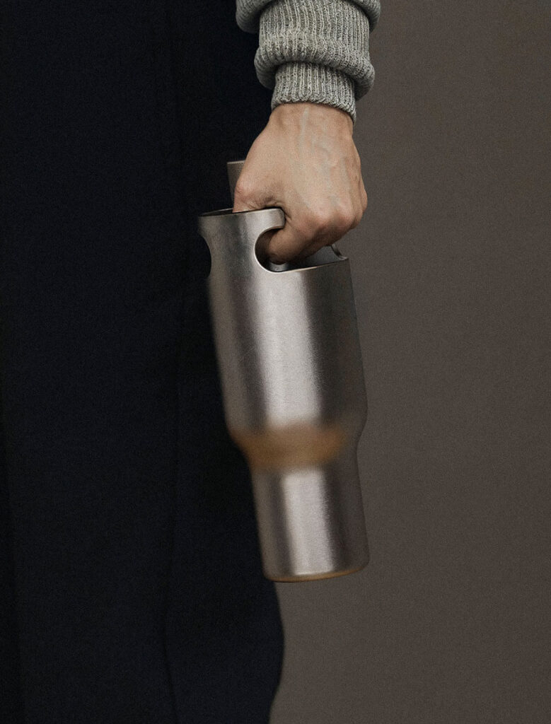 Hand holding metal water bottle. Borrel Water Bottle by All Design Lab.