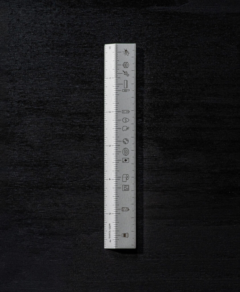 Top view of metal ruler showing inches and icons. Ruler with icons by All Design Lab.