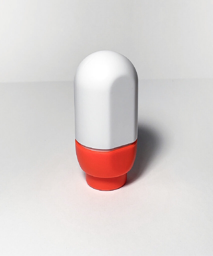 A soft, round spray bottle with a flat back standing on its top. NOK Pop refillable spray bottle by All Design Lab.